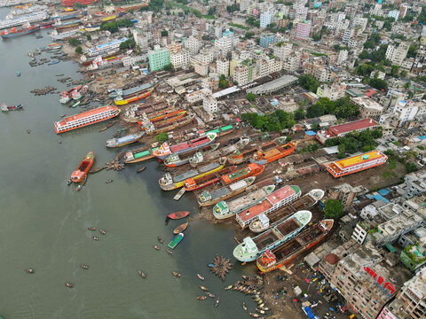 Aerial view of Sadarghat Launch Terminal with numerous passenger launches and cargo vessels docked along the Buriganga River in the dense urban landscape of Dhaka, Dhaka Division, Bangladesh.