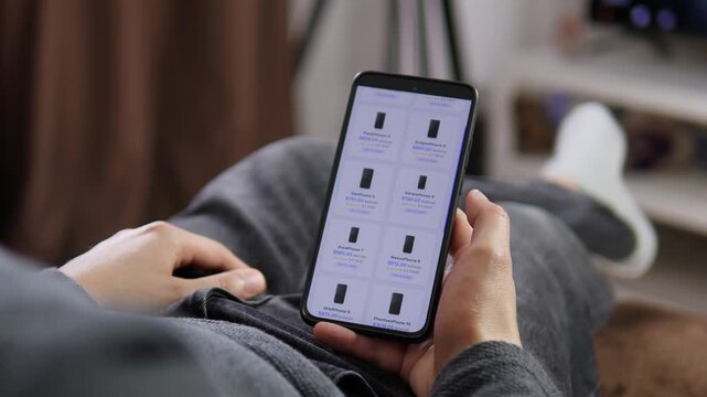 Shopper scrolls through smartphone listings and compares prices, ratings and models, capturing the rise of mobile commerce and informed digital buying decisions.