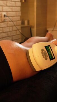 Vacuum roller massage. Lymphatic drainage and RF lifting stage. Dim atmospheric warm light. Masseuse massages a woman's leg with a device. self-care, care, weight loss. slow motion
