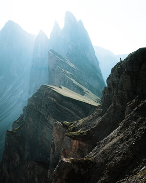 Dolomites mountain peaks at Seceda with person standing on cliff, South Tyrol, Italy