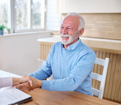 Happy senior old man or businessman client make financial insurance estate business deal contract signing and shaking hands, agent lawyer, satisfied mature customers signing contract meeting bank mana