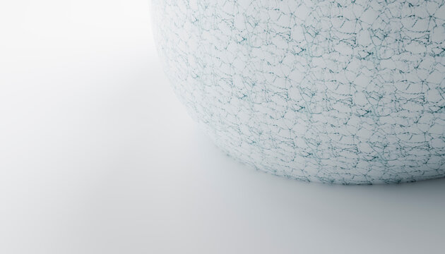 A white sphere with cracked texture on a smooth surface