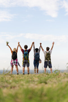 Group of Friends Celebrating at the Top of a Hill After Hiking in Nature During Daytime