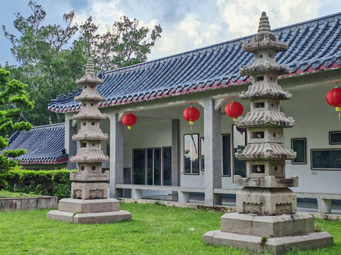 A pair of five-story stone pagodas beside Chinese corridor in temple courtyard