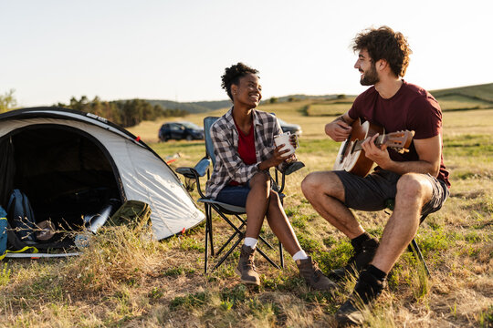 Camping in Nature With Friends Enjoying Music and Coffee Near a Tent