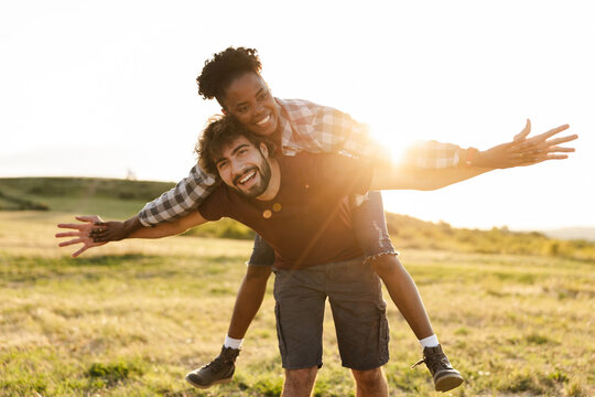 Happy Couple Enjoying a Day Outdoors With a Sunset View on a Grassy Field