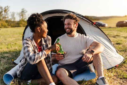 Couple Enjoys Drinks Outside Their Tent During Camping Trip in the Countryside