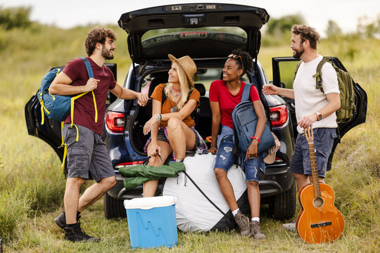 Group of Friends Preparing for a Camping Trip at a Scenic Outdoor Location