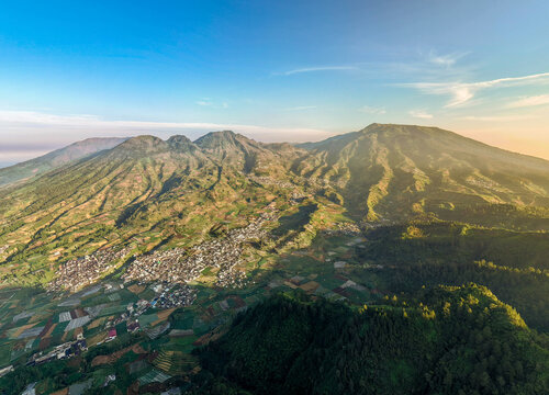 Aerial view of Tambi tea plantations and the surrounding village nestled in the mountainous landscape of Kejajar, Central Java, Indonesia.