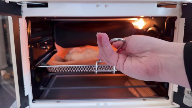Removing freshly baked homemade apple strudel from oven after baking