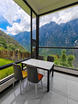 Modern glass room overlooking a mountain landscape