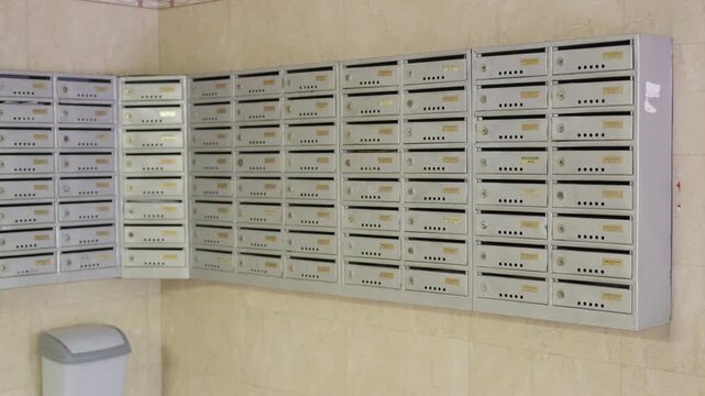 Series of three frames showing a row of gray mailboxes in a hallway, with a trash bin positioned nearby against a beige wall in a residential building setting