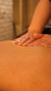 masseuse doing back massage after chocolate wrap procedure. warm dim light. self-care and self-care