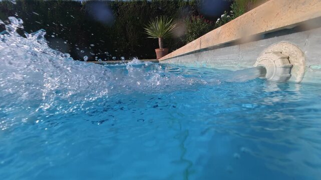 Submerged view of air bubbles rising from pool return outlets and creating flowing patterns in clear swimming pool water. Useful as stock footage for water, fitness, wellness and environmental concept