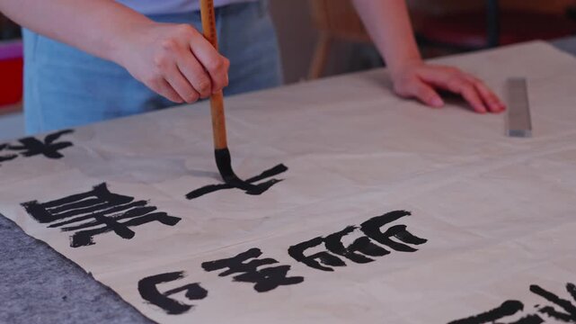 Indoor figure holding brush writing traditional Chinese characters