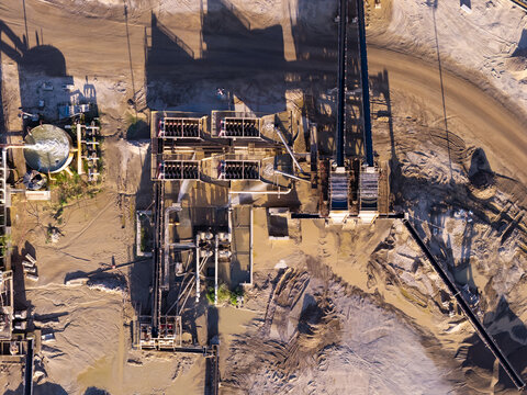 Aerial view of the aggregate gravel and sand mining operation featuring industrial processing equipment, conveyor belts, and water tanks in Bluffdale, Utah, United States.