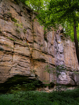 Majestic towering sandstone canyon wall and lush green forest foliage at Starved Rock State Park in Illinois