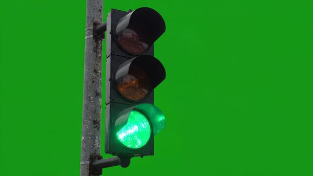 Standard urban traffic light pole switching colors from red to yellow then green against a chroma key green screen background
