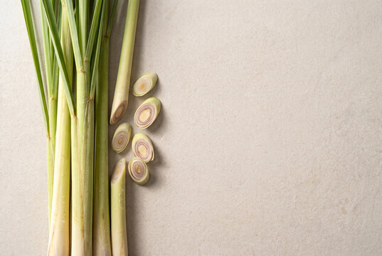 Fresh Thai lemongrass stalks with cut sections on light stone background and copy space