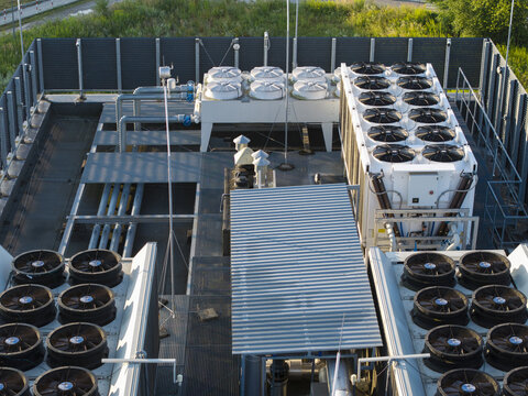 Aerial view of industrial rooftop cooling units with large fans and metal piping in Krakow, Lesser Poland Voivode, Poland.