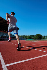 Obraz premium Male runner sprinting away on outdoor athletics track