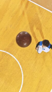 Low Overhead View of a Basketball Player Reaching for the Ball