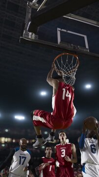 Basketball Player Dunking the Ball Over Defenders in a Packed Arena