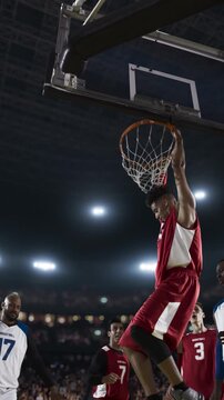 Basketball Player Dunking the Ball as Teammates Watch in a Packed Arena