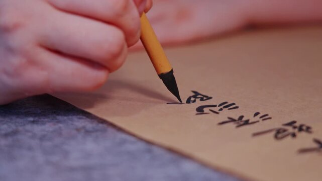 Macro shot of a small brush writing small Chinese characters