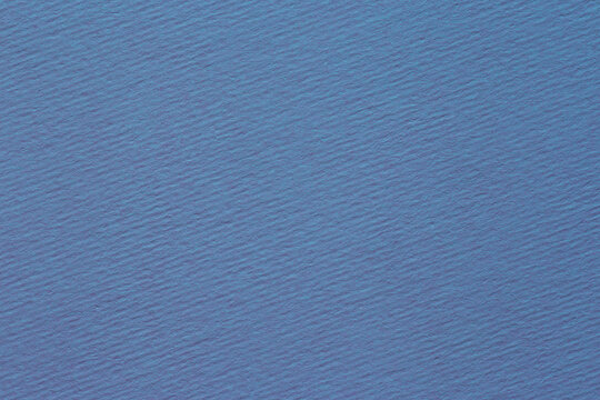 blue backdrop: close up of diagonally ridged craft paper