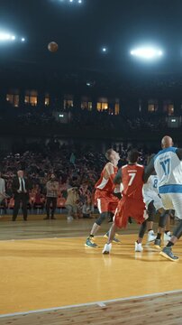 Basketball Player Shooting Over a Defender in a Packed Arena