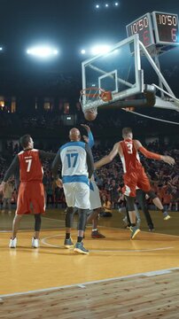 Basketball Player Dunking the Ball as Defenders React in a Packed Arena