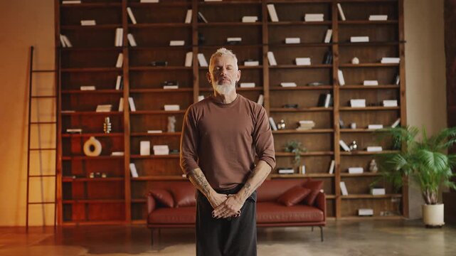 Toned middle-aged man performing martial arts routine at home, active lifestyle