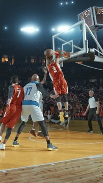 Basketball Players Celebrating a Score with Teammates in a Packed Arena