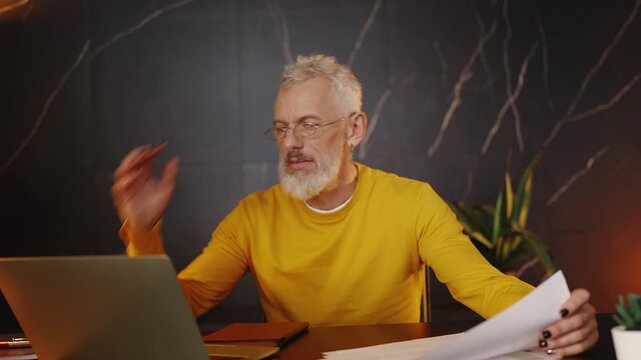 Focused financial analyst in his 50s preparing a report and typing on a laptop