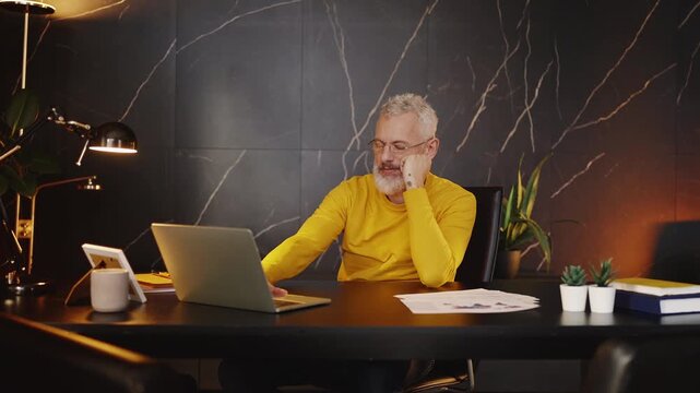 Company boss feeling stressed while working on a laptop, financial problems