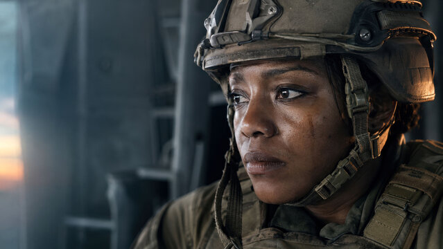 Emotional Black female soldier in combat helmet with tears on her face, powerful portrait of military stress, trauma, resilience and the human cost of war