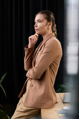 Elegant young woman reflecting thoughtfully in a modern office environment