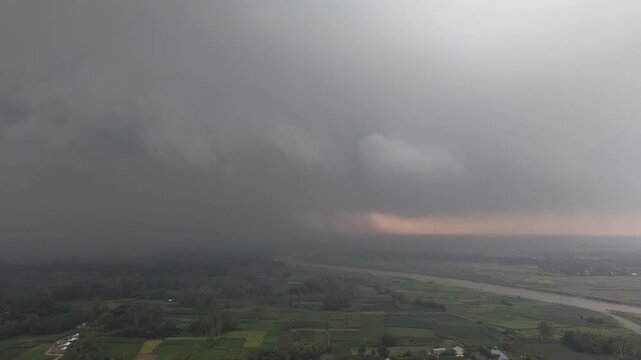 Approaching storm clouds over rural landscape river and farmland aerial view dramatic weather