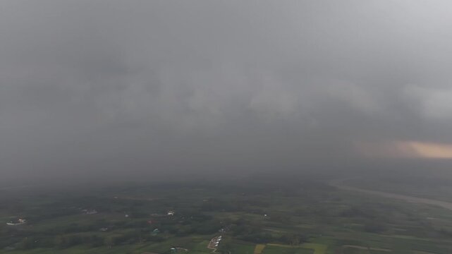 Approaching storm clouds over rural landscape river valley aerial view dramatic weather overcast