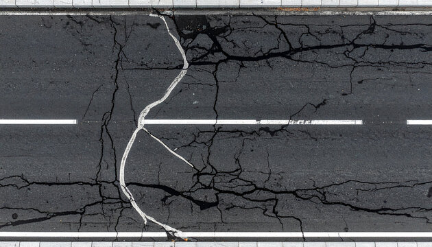 経年劣化が生み出す無骨なアスファルト舗装のグランジ背景テクスチャ
Weathered asphalt pavement grunge texture with natural cracks and worn surface