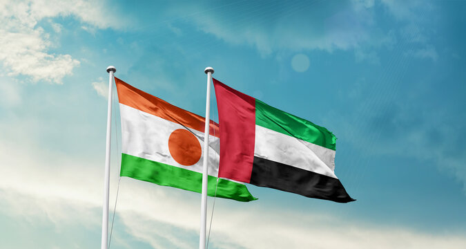 Niger and UAE friendship flags are waving in the sky. Double country Flag waving with mast. Niger UAE national flag for agreement.