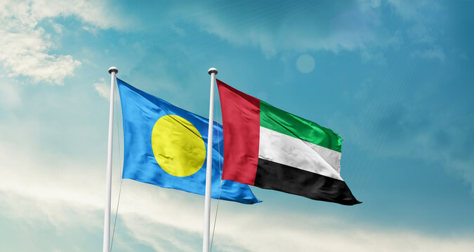 Palau and UAE friendship flags are waving in the sky. Double country Flag waving with mast. Palau UAE national flag for agreement.
