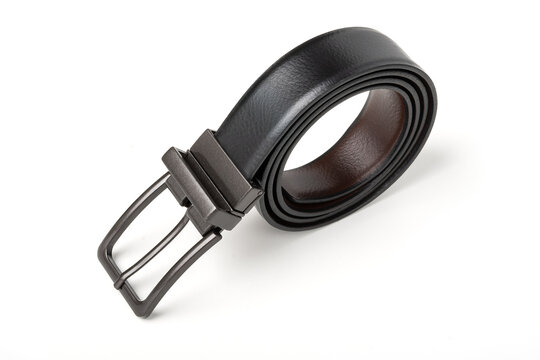 Reversible black and brown men's leather belt with a dark metal buckle, coiled on an isolated white background.