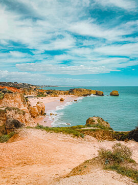 Sandy beach cove surrounded by golden cliffs in the Algarve, Portugal