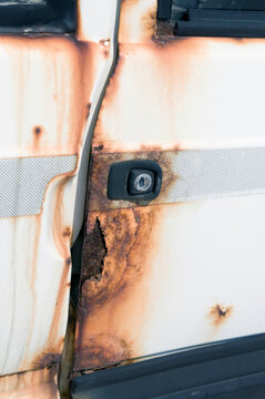 the rusted door of a white car