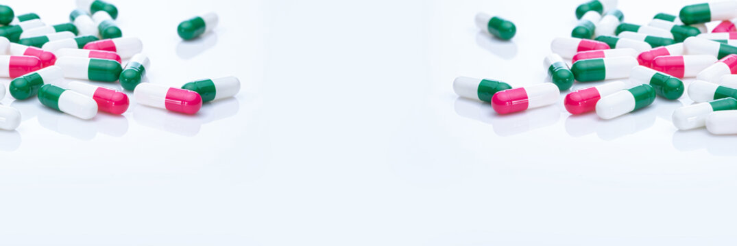 Capsules pill spread on white background. Prescription drugs. Capsule pill frame banner. Green, pink, and white color capsule pills. Pharmaceutical industry. Medication and pharmacology. Health care.