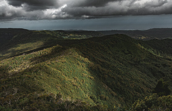 Dramatic storm clouds over green rolling hills
