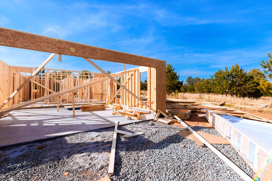 Wooden beams framing at construction site with building materials scattered around during framework