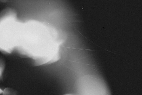 retro film overlay effect with scratch dust and light leaks, retro grain noisy film distressed texture light leak flare on black background,black and white abstract light background